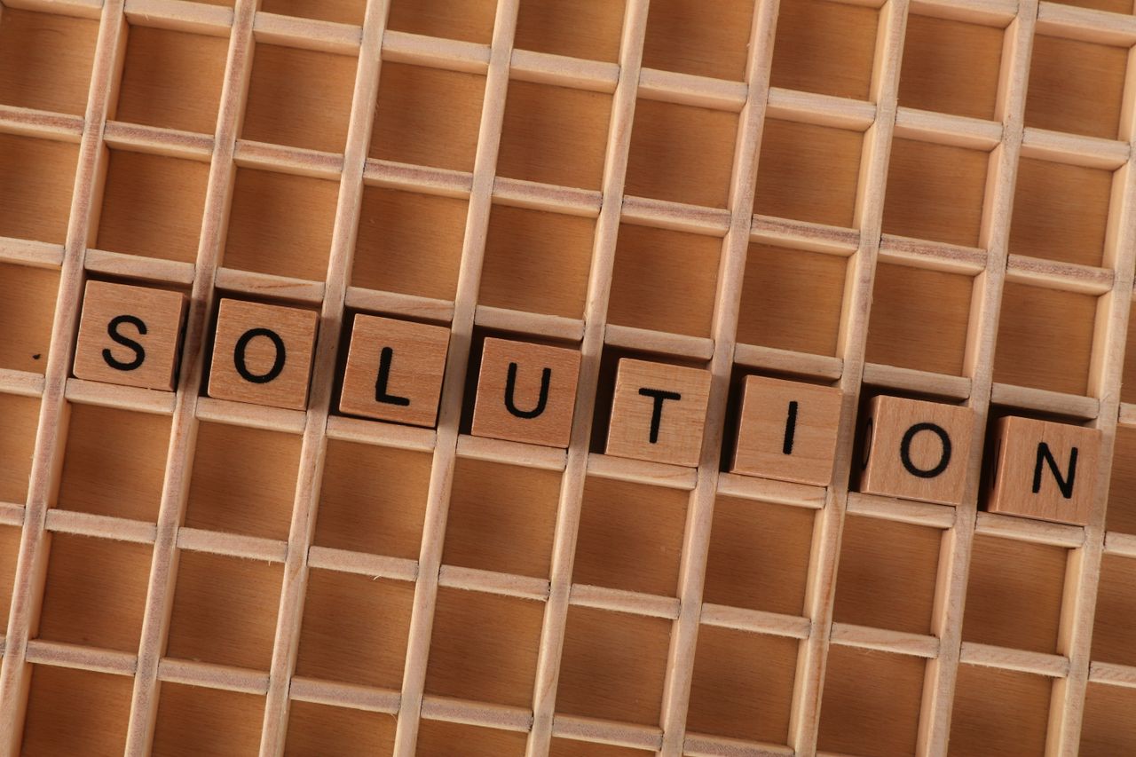 Wooden blocks spelling 'solution' in a grid, symbolizing problem-solving.